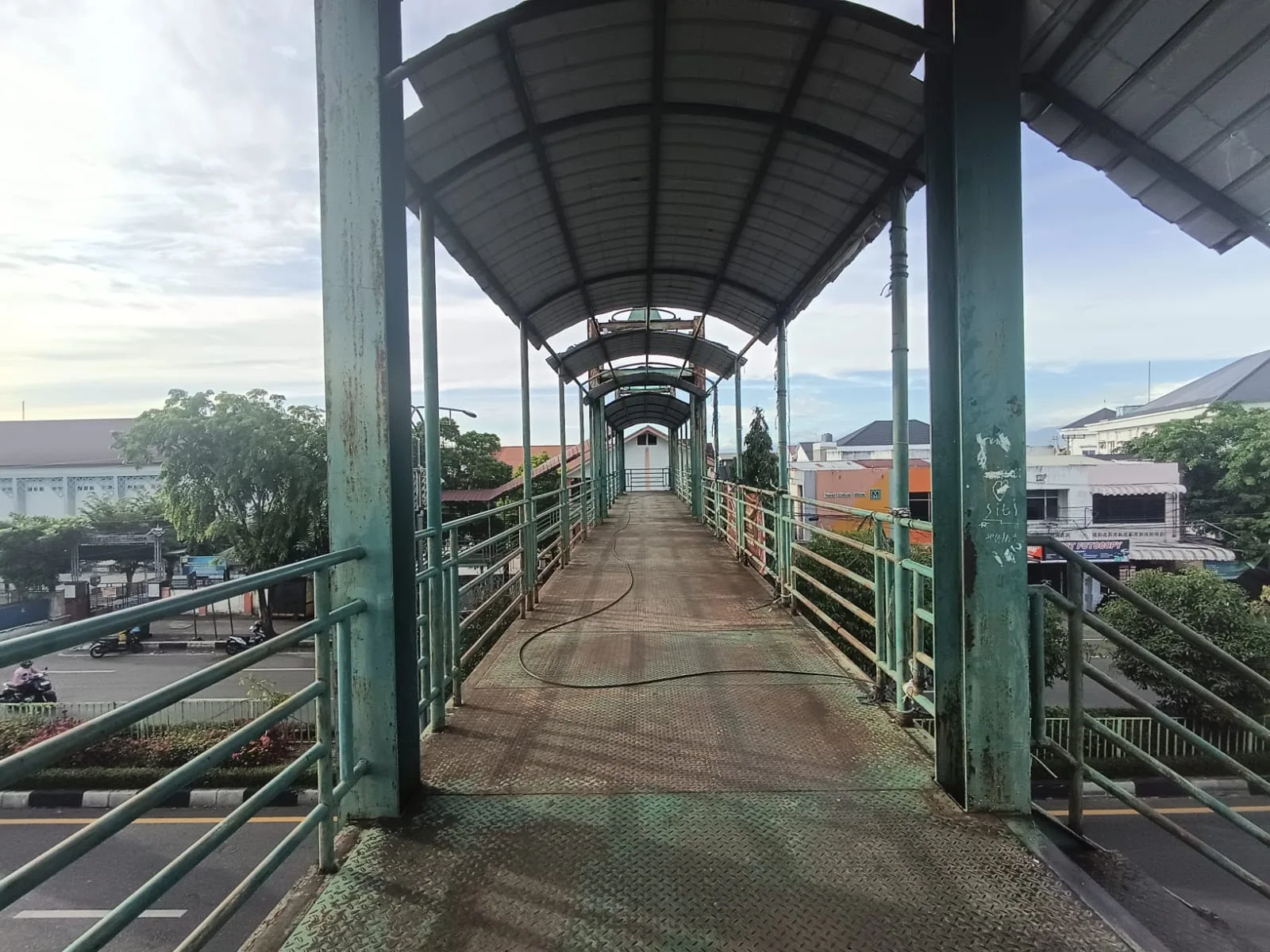 Banda Aceh - Jembatan Penyeberangan Orang (JPO) Peurada Banda Aceh yang melintang di Jalan Teuku Nyak Arief terlihat tidak terawat, sejumlah atap seng terlepas dan struktur besi mulai berkarat sehingga menimbulkan kekhawatiran bagi pengguna, Sabtu (6/6/2026).