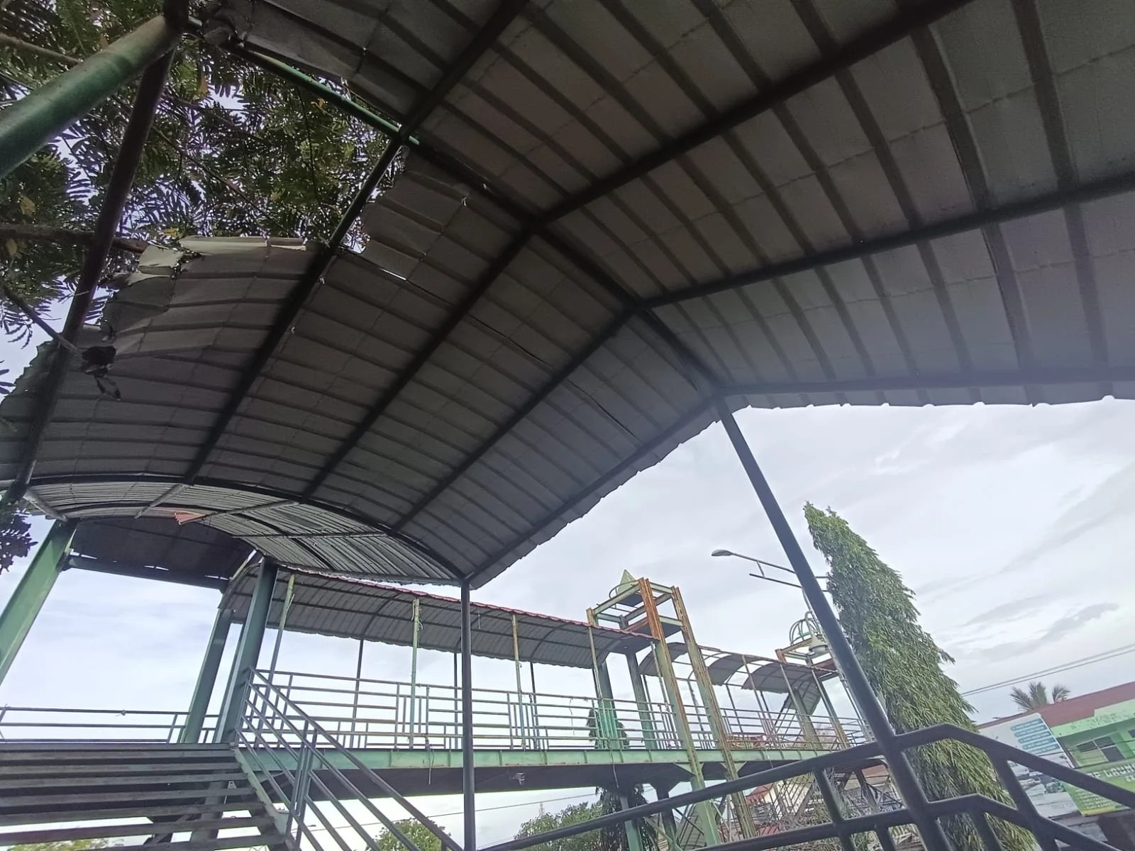 Banda Aceh - Jembatan Penyeberangan Orang (JPO) Peurada Banda Aceh yang melintang di Jalan Teuku Nyak Arief terlihat tidak terawat, sejumlah atap seng terlepas dan struktur besi mulai berkarat sehingga menimbulkan kekhawatiran bagi pengguna, Sabtu (6/6/2026).
