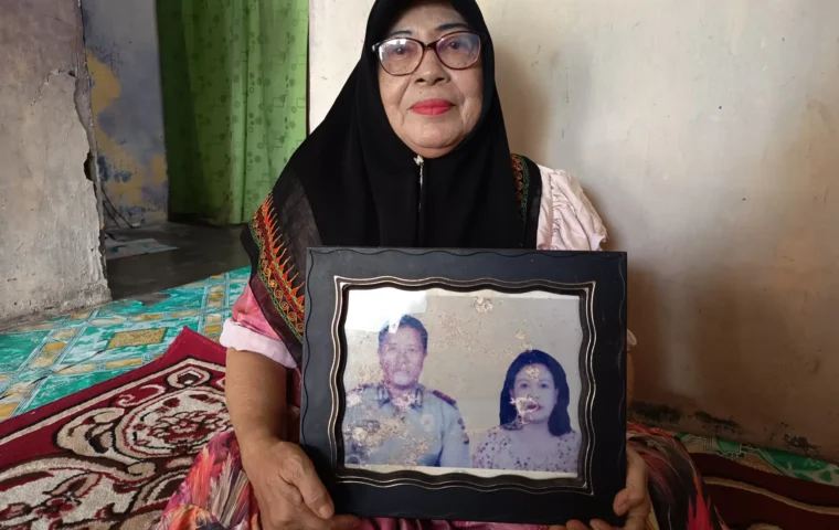 Korban konflik Aceh, Rasyidah memegang foto almarhum suaminya dan diri sendiri di rumahnya. Sumber foto: /Elza