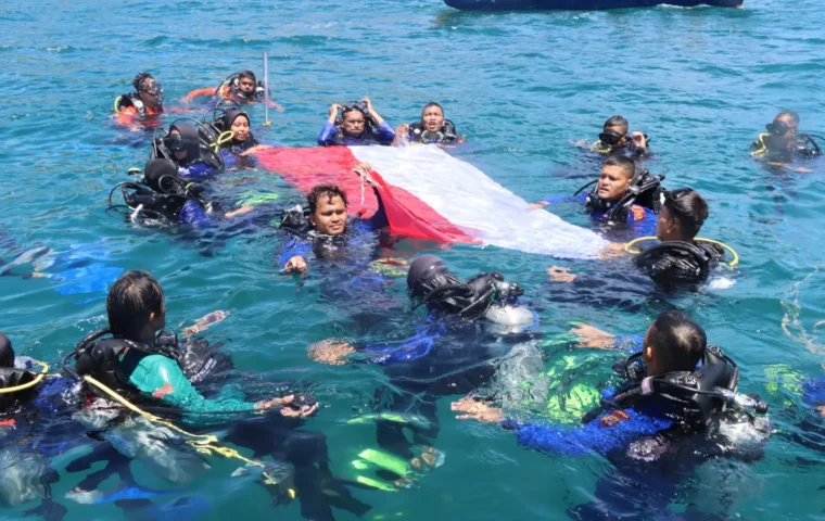 Bendera Merah Putih dibentangkan dan dikibarkan di dasar laut Krueng Raya sebagai simbol semangat kemerdekaan dan kecintaan terhadap Tanah Air.