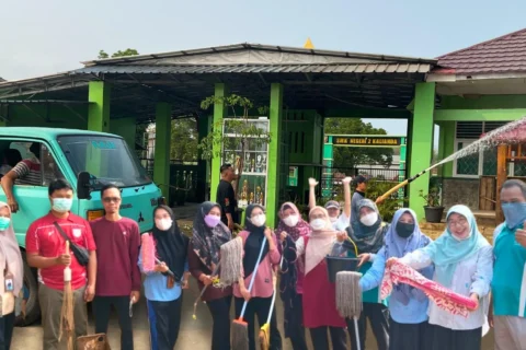Guru MTsN 1 Lamsel Bersihkan Madrasah dari Abu Vulkanik